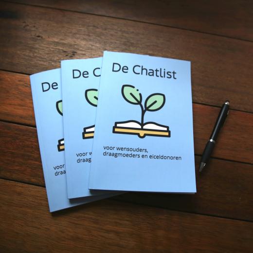 3 Chatlist boekjes op tafel met pen, op de voorkant een opengeslagen boekje waar een boom uit groeit de woorden Voor wensouders, draagmoeder en eiceldonoren
