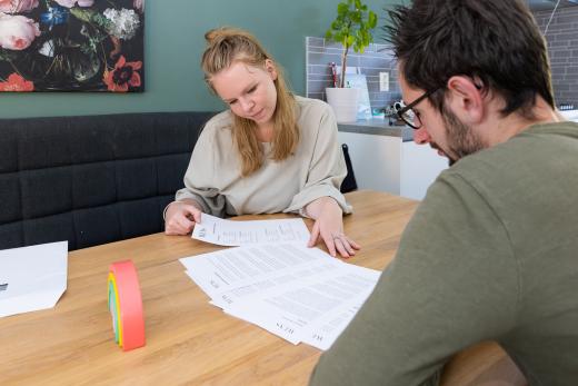 Draagmoeder en wensvader nemen samen de papieren door