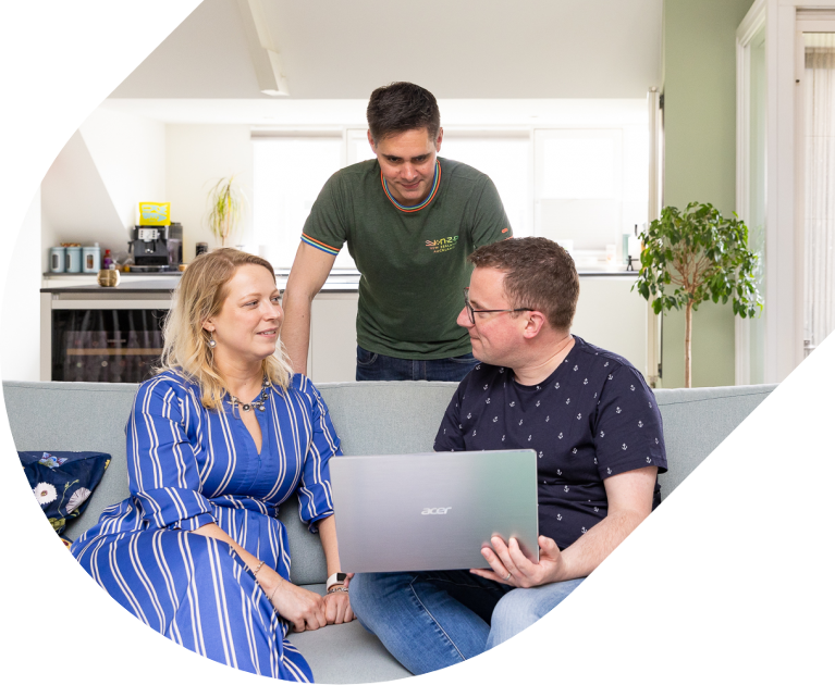 een vader en draagmoeder op de bank met daar achter een andere vergader in gesprek